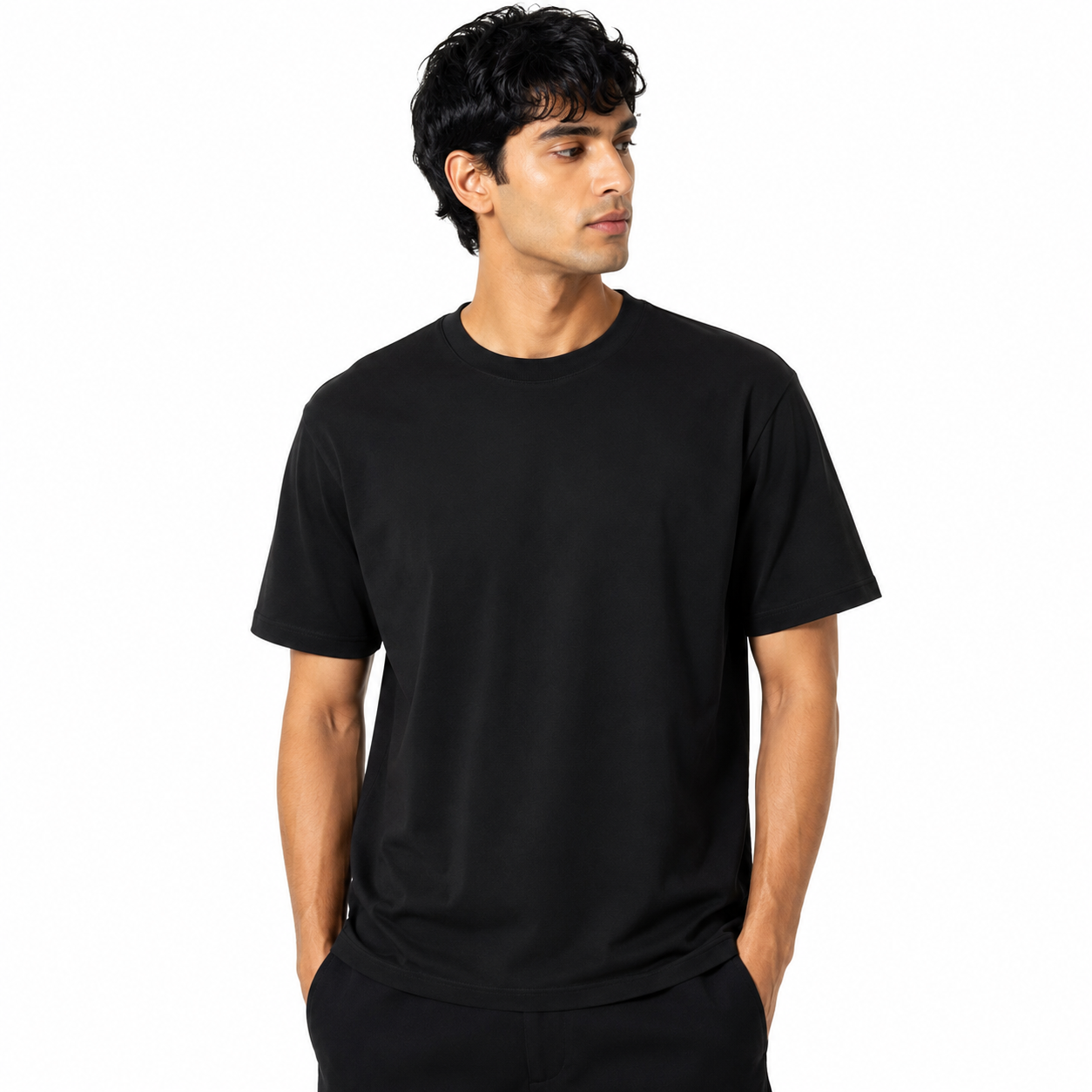 A man wearing a plain black short-sleeve crewneck t-shirt, standing against a solid white background.