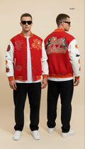 Man wearing a red varsity jacket with white lettering and black pants on a beige background